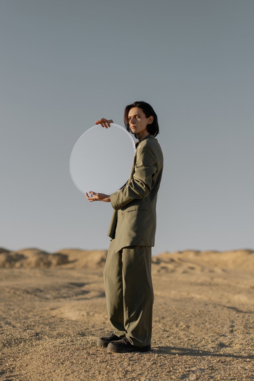 Man in Gray Suit Holding White Round Hand Fan